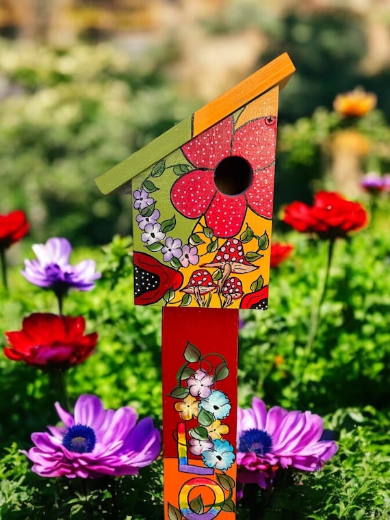 Colorful Birdhouse in Yellow and Green with welcoming Red Flowers