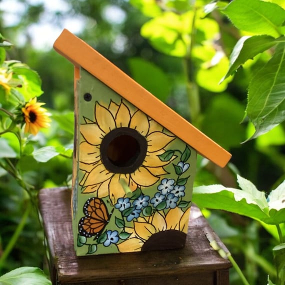 Colorful Birdhouse with Welcoming Sunflowers