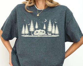 May include: Dark heather gray t-shirt featuring a cream-colored camping scene with a camper, trees, moon, and stars. The shirt has short sleeves and a relaxed fit. The text "Dark Heather" is printed at the bottom left.