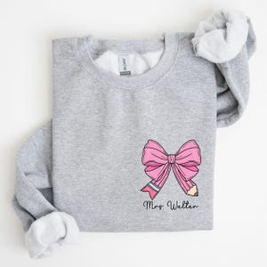 custom name teacher pink coquette bow pencil sweatshirt with pocket size design