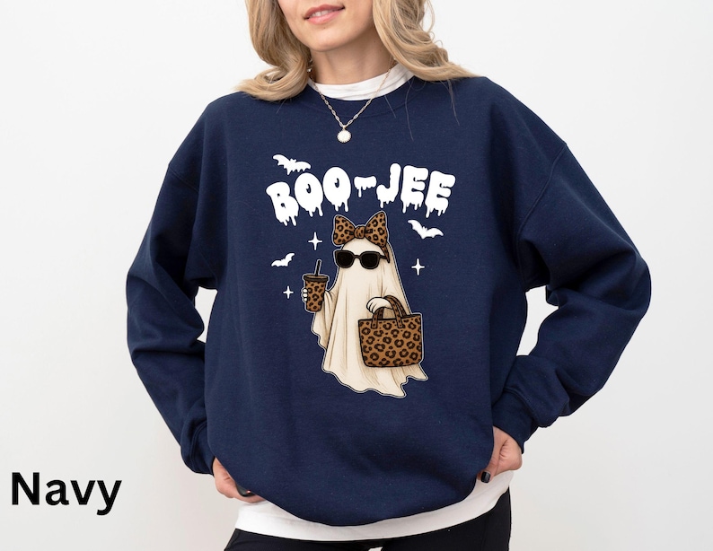 Op de afbeelding: Marineblauwe sweatshirt met een spookafbeelding met een zonnebril en een luipaardstrik, met een drankje en een handtas. De tekst "BOO-JEE" staat boven het spook, met vleermuizen en sterren. Halloween-thema.