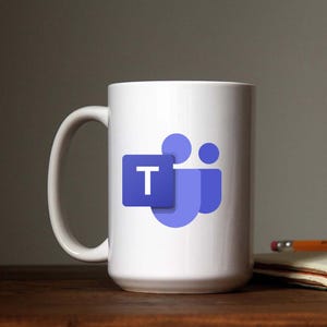 May include: White ceramic mug with a blue Microsoft Teams logo featuring the letter "T" and three stylized people.