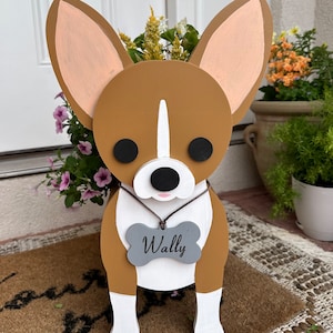 May include: A wooden planter shaped like a brown and white chihuahua dog with a gray bone-shaped tag that says "Wally".