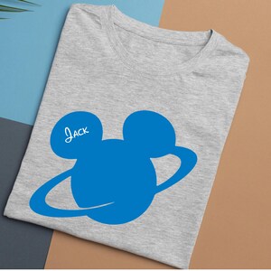 Peut inclure: T-shirt gris clair avec un motif bleu repr&eacute;sentant une t&ecirc;te de personnage de dessin anim&eacute; et le nom "Jack" en &eacute;criture blanche. Le motif comprend deux grands cercles et une ligne incurv&eacute;e.