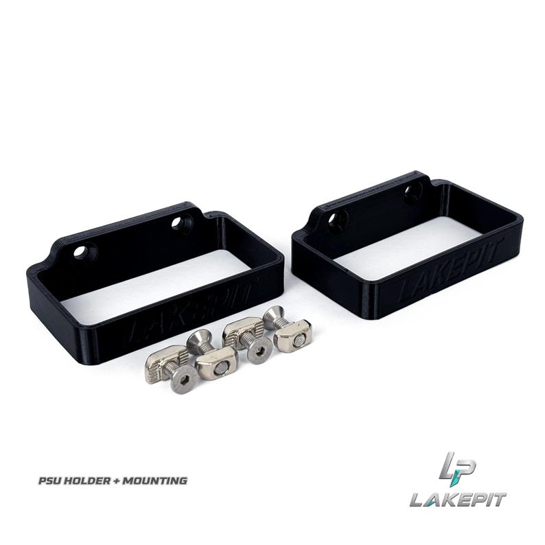 May include: Two black rectangular PSU holders with the text LAKEPIT embossed on the front side. Each holder features two circular mounting holes. Included are four silver-colored metal T-nuts and four matching screws for secure installation.
