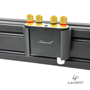 Puede incluir: Un dispositivo de audio Nobsound negro con cuatro bornes de conexión dorados con anillos rojos y negros en el panel superior. La parte frontal muestra el logotipo de Nobsound en blanco y un mando plateado es visible abajo a la derecha.