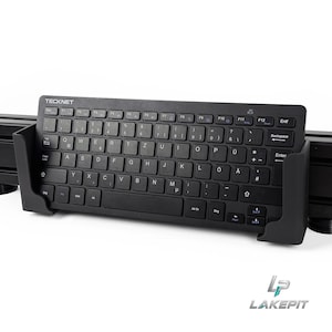 May include: A black TeckNet wireless keyboard with a QWERTZ layout is held in a black plastic mounting bracket. The keyboard features white lettering on the keys, including function keys, a numeric row, and standard command keys like Backspace and Enter.
