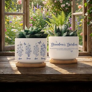 May include: Two white ceramic planters with succulents, sitting on wooden coasters. One planter has blue floral designs and names: Lana, Brian, Louis, and Benny. The other says "Grandma's Garden" with a quote.