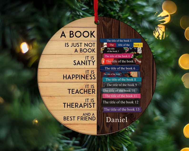 May include: A round wooden ornament with the text "A book is just not a book. It is sanity, happiness, teacher, therapist, and a best friend."  The ornament also features a stack of books with the text "The title of the book 1, The title of the book 2, The title of the book 3, The title of the book 4, The title of the book 5, The title of the book 6, The title of the book 7, The title of the book 8, The title of the book 9, The title of the book 10, The title of the book 11, The title of the book 12, The title of the book 13" and the name "Daniel".