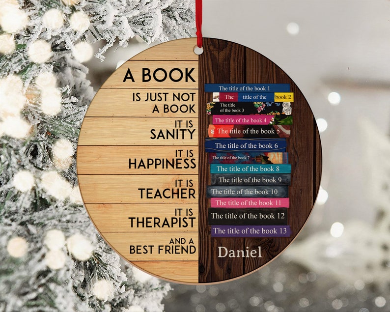 May include: A round wooden ornament with a quote about books. The quote reads "A book is just not a book. It is sanity. It is happiness. It is teacher. It is therapist. And a best friend." The other side of the ornament has a list of book titles with the name "Daniel" at the bottom.