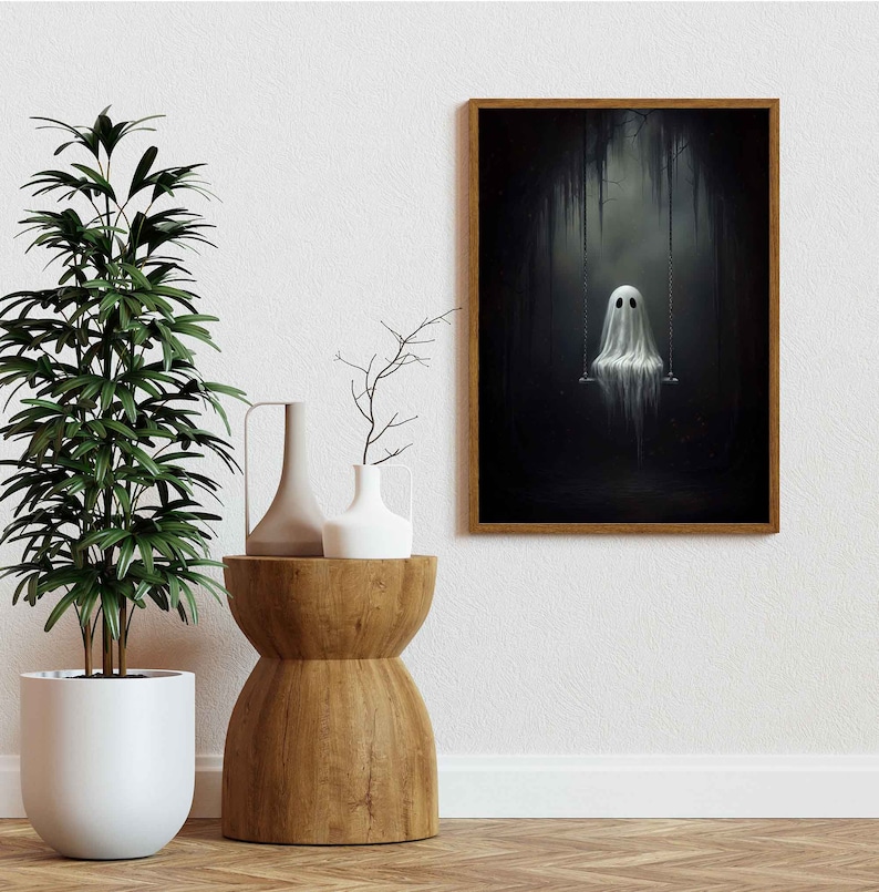 May include: A framed illustration of a white ghost sitting on a swing in a dark, shadowy forest. The ghost has two black eyes and a simple, white, draped form.