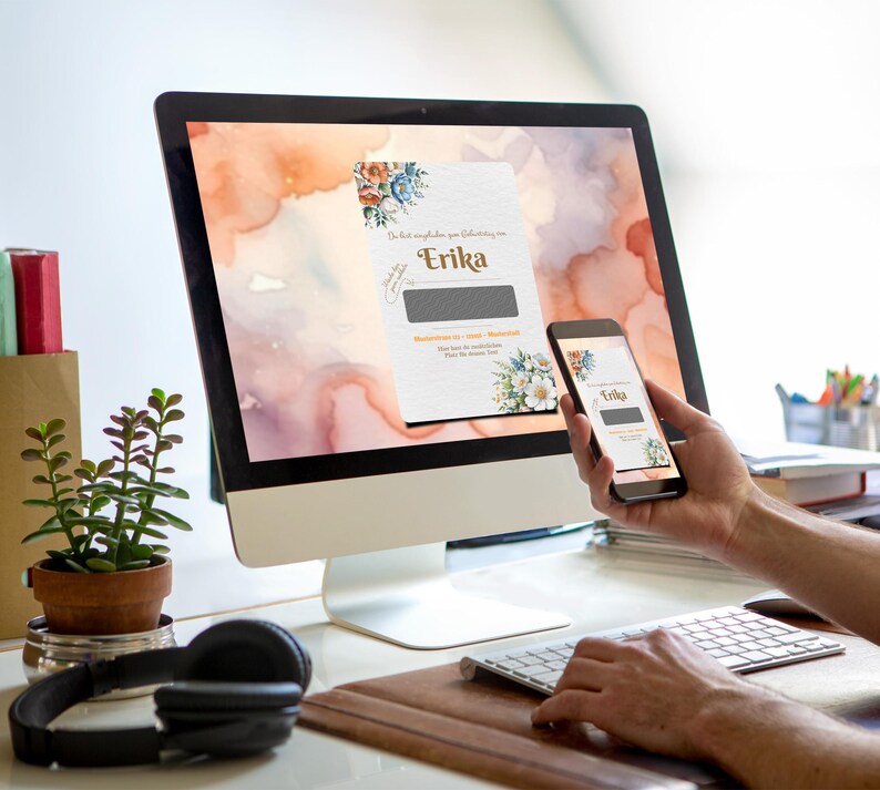 May include: A computer screen and a smartphone display a digital card with a watercolor floral design and the text "Die beste Gl&uuml;ckw&uuml;nsche zur Geburt von Erika".