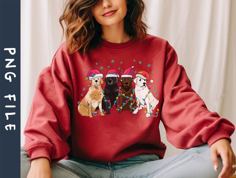 Puede incluir: Sudadera roja con un dise&ntilde;o navide&ntilde;o que presenta cuatro perros con gorros de Pap&aacute; Noel y rodeados de luces navide&ntilde;as de colores.