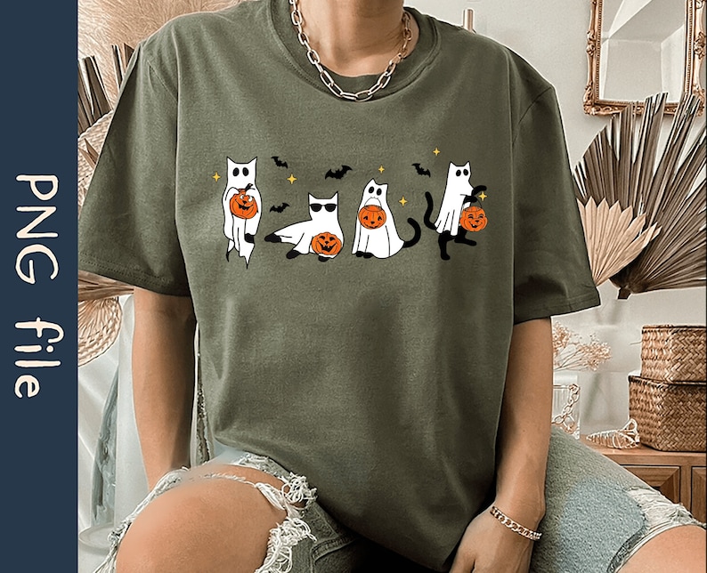 May include: Olive green t-shirt featuring a Halloween-themed graphic. The design includes four cartoon cats dressed as ghosts, each holding a jack-o'-lantern. Bats and stars are also included in the design. The shirt is a PNG file.