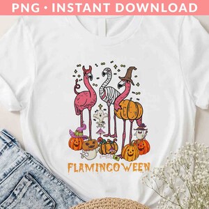 May include: White t-shirt with a pink flamingo wearing a witch hat and holding a pumpkin. The text "Flamingoween" is printed below the image.