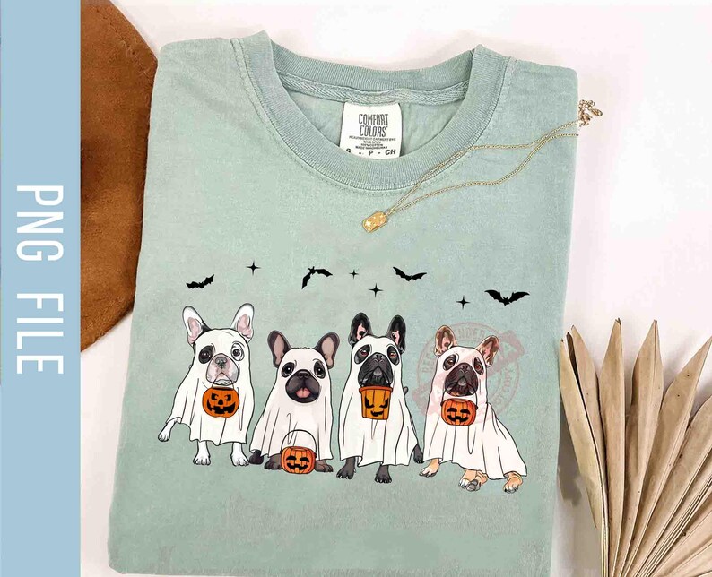 Pu&ograve; includere: Una maglietta verde chiaro con un design di quattro bulldog francesi vestiti da fantasmi che tengono zucche. Il testo "Comfort Colors" &egrave; sulla maglietta.