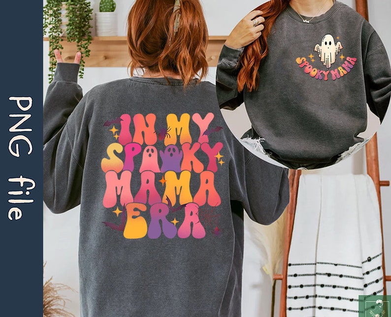 Op de afbeelding: Twee sweatshirts met een Halloween-thema. Een sweatshirt is zwart met de tekst "In My Spooky Mama Era" in regenboogkleuren. De andere sweatshirt is zwart met een witte geest en de tekst "Spooky Mama".