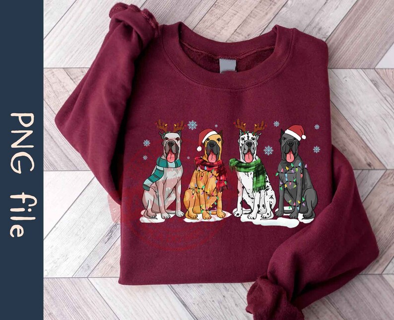 May include: A maroon sweatshirt with a Christmas-themed design featuring four Great Danes wearing festive attire. The dogs are wearing Santa hats, reindeer antlers, and Christmas lights. The design is centered on the sweatshirt.