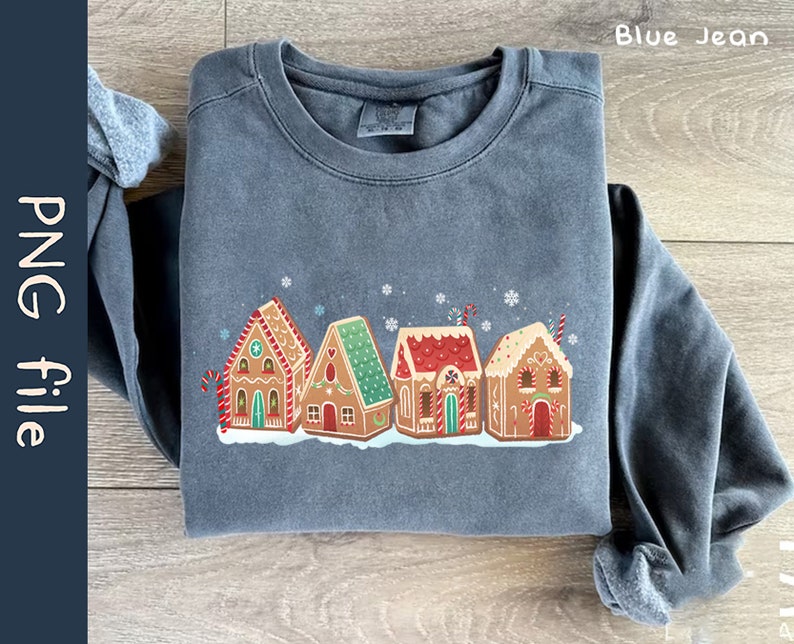 May include: A blue sweatshirt with a graphic of five gingerbread houses with red and white candy canes, red and white candy hearts, and white snowflakes. The houses are decorated with red and white candy.