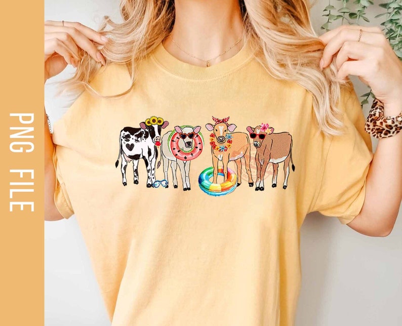 May include: A yellow t-shirt with a graphic of four cows wearing flower crowns and holding pool floats. The cows are black and white, brown and white, and brown.