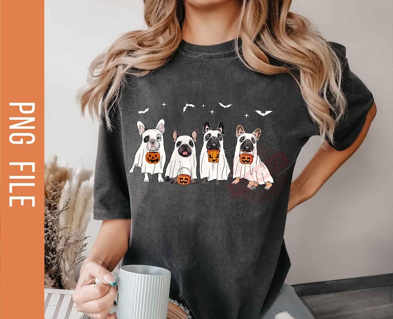 Pu&ograve; includere: Una maglietta grigia scura con una grafica di quattro bulldog francesi vestiti da fantasmi che tengono zucche. La maglietta ha un collo rotondo e maniche corte.