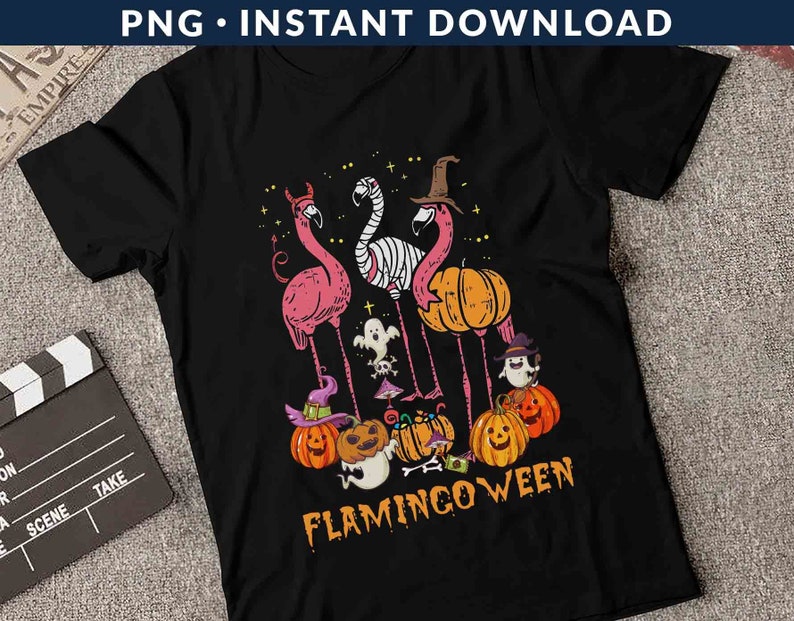May include: Black t-shirt with a graphic of pink flamingos with witch hats and pumpkins. The text "Flamingo-ween" is printed on the shirt.