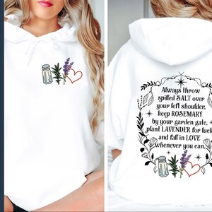 May include: White hoodie with a black graphic print on the back that says "Always throw spilled SALT over your left shoulder, keep ROSEMARY by your garden gate, plant LAVENDER for luck and fall in LOVE whenever you can." The graphic also includes a salt shaker, lavender, and a heart.