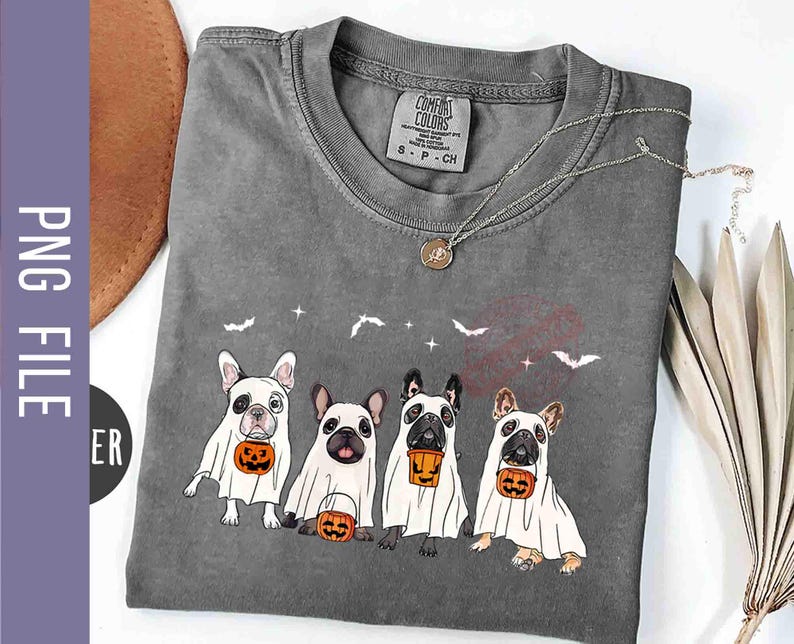 Pu&ograve; includere: Una maglietta grigia con una grafica di quattro bulldog francesi vestiti da fantasmi che tengono zucche. Il testo "Comfort Colors" &egrave; stampato sulla maglietta.