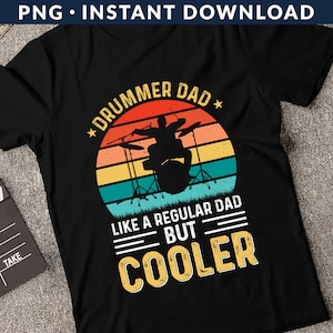 May include: Black t-shirt with a vintage-style graphic of a drummer playing drums. The text reads "Drummer Dad * Like a Regular Dad But Cooler".