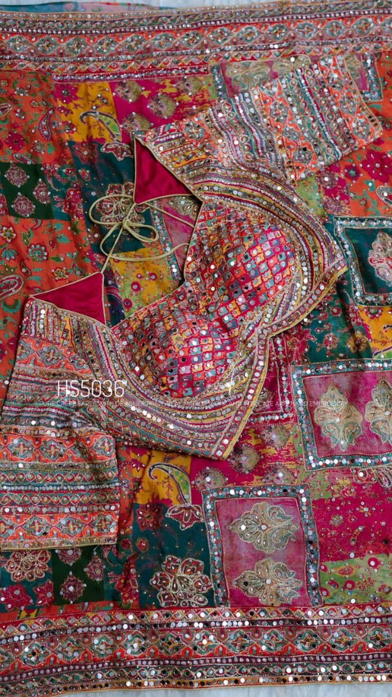 May include: A vibrant, patchwork-style textile featuring a blouse and fabric with intricate embroidery and mirror embellishments. The blouse has a deep pink lining and a tie closure. The fabric displays a variety of colors and patterns, including paisley and floral designs. The text "HS5036" is visible.