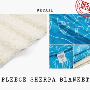May include: A blue fleece sherpa blanket with a white sherpa lining. The blanket features a white geometric pattern on a blue background. The blanket is folded in half and the white lining is visible.
