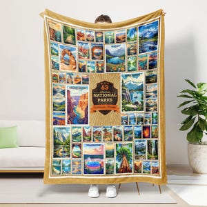May include: A gold fleece blanket with a collage of 63 national parks in the United States. The blanket features a large, gold circle with the text "63 National Parks" and "Discover & Wander".
