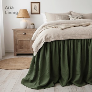 Könnte beinhalten: Ein Schlafzimmer mit einem Bett mit einem grünen Bettrand und beiger Bettwäsche. Ein Nachttisch aus Holz mit einer Lampe und ein kleiner runder Teppich sind ebenfalls zu sehen. Der Text "Aria Living" befindet sich oben links.