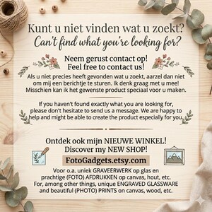 Op de afbeelding: Een houten bord met tekst in het Engels en Nederlands, waaronder "Can't find what you're looking for?" en "Discover my NEW SHOP!" Het bord promoot ook gegraveerd glaswerk en fotoprints.