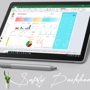 May include: A Microsoft Surface Pro tablet with a gray stylus pen, displaying a spreadsheet with a safety dashboard. The dashboard includes charts, graphs, and data related to safety performance. The text "Safety Dashboard" is written in white cursive on a gray background.