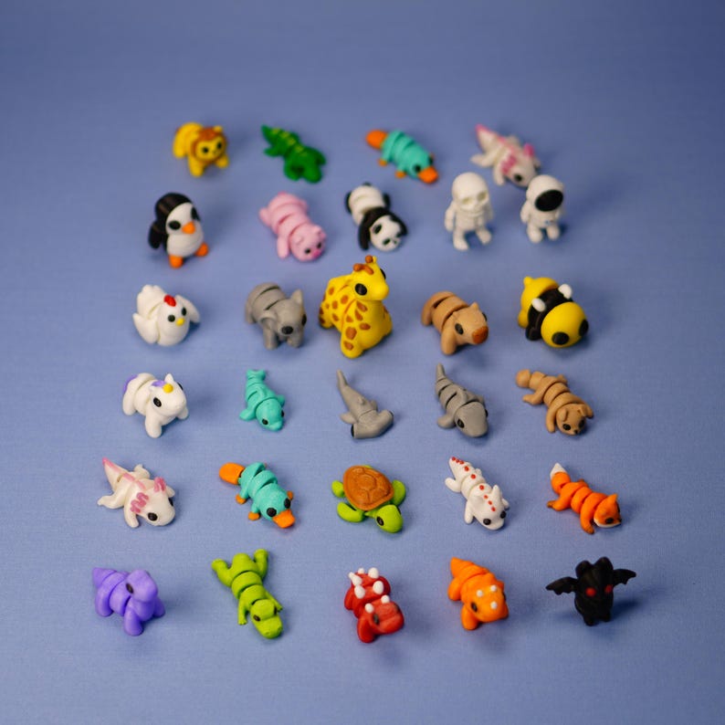 Op de afbeelding: Een verzameling van 25 kleurrijke dierenfiguren, waaronder een giraffe, een pingu&iuml;n, een schildpad, een haai, een dinosaurus, een vogelbekdier, een bij, een kip, een draak en meer. De figuren zijn gemaakt van een zacht, buigzaam materiaal en zijn perfect voor fantasierijk spelen.