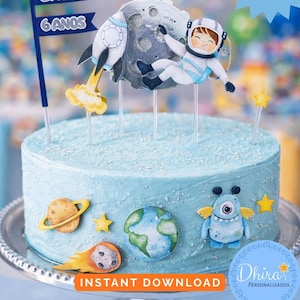 May include: A light blue frosted cake decorated with space-themed toppers, including a rocket, astronaut, planets, and stars. The cake has the text "ENZO 6 ANOS" on a flag and "Instant Download" text.