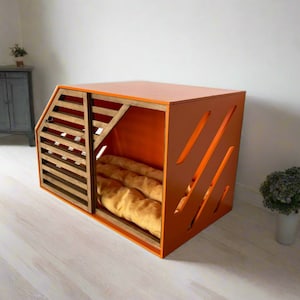 May include: Orange wooden dog crate with a slatted door and a brown cushion inside. The crate has a modern design with diagonal cutouts on the front.