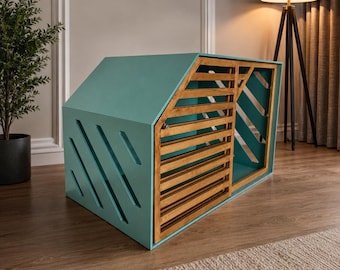May include: A teal-colored pet crate with a slanted roof design, featuring a wooden slatted sliding door and diagonal cut-out ventilation slots on the side panel. The structure is constructed from solid teal panels and natural wood slats.