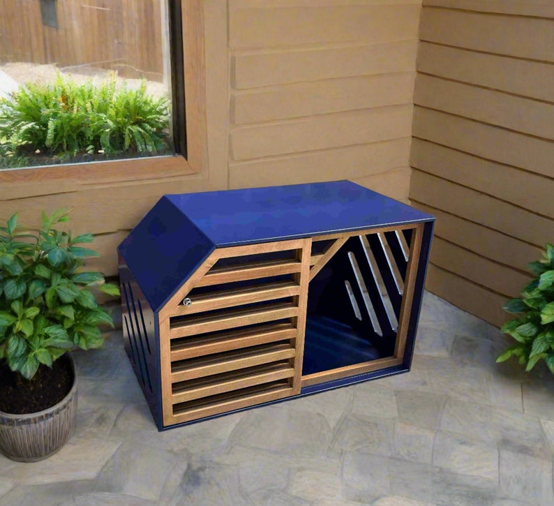 May include: A blue wooden dog house with a slatted wooden door and a blue interior. The house is sitting on a grey concrete patio.