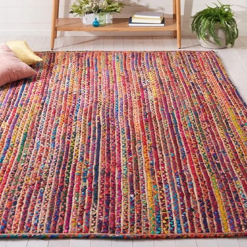 May include: A rectangular area rug with a vibrant, multicolored striped design. The rug features vertical stripes in shades of red, pink, blue, yellow, and orange. The rug is made of woven material and adds a pop of color to any room.