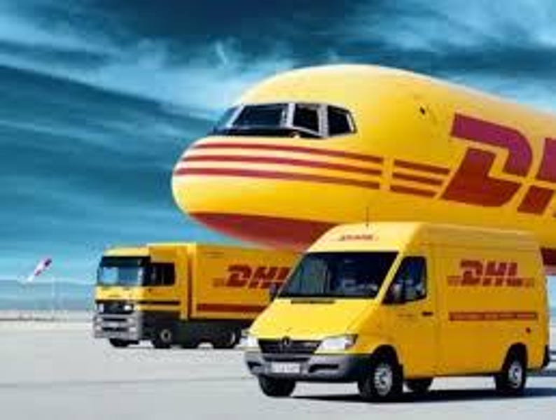 May include: A yellow DHL airplane, truck, and van are parked on a tarmac against a blue sky. The vehicles and plane have the DHL logo in red. The plane is in the background, with the truck and van in the foreground.