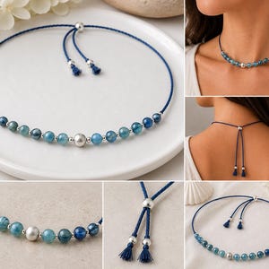May include: A blue cord necklace featuring a series of round blue gemstone beads and small silver-toned metal beads. The center bead is a larger silver-toned sphere. The necklace includes an adjustable sliding closure with two dangling cord ends.
