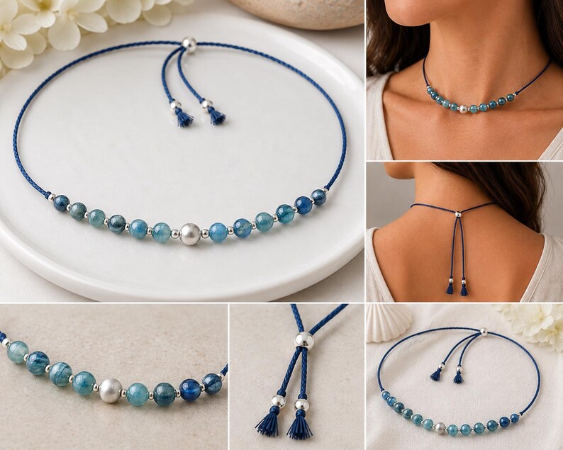 May include: A blue cord necklace featuring a series of round blue gemstone beads and small silver-toned metal beads. The center bead is a larger silver-toned sphere. The necklace includes an adjustable sliding closure with two dangling cord ends.
