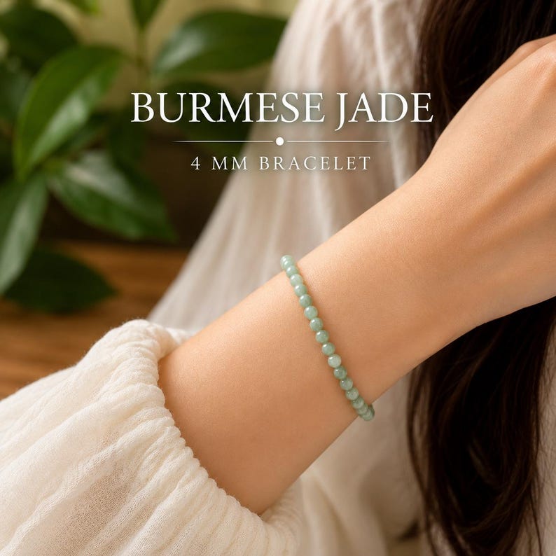 May include: A bracelet made of small, light green Burmese jade beads, each measuring 4 mm in diameter. The text BURMESE JADE 4 MM BRACELET is displayed in white lettering above the jewelry, which is worn on a wrist.