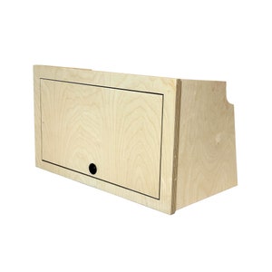 May include: A light wood cabinet with a hinged door and a black knob. The cabinet is made of plywood and has a simple, modern design.