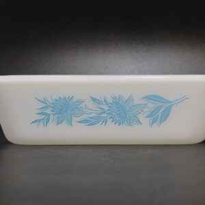 May include: White rectangular baking dish with a blue floral design. The design features stylized flowers and leaves.