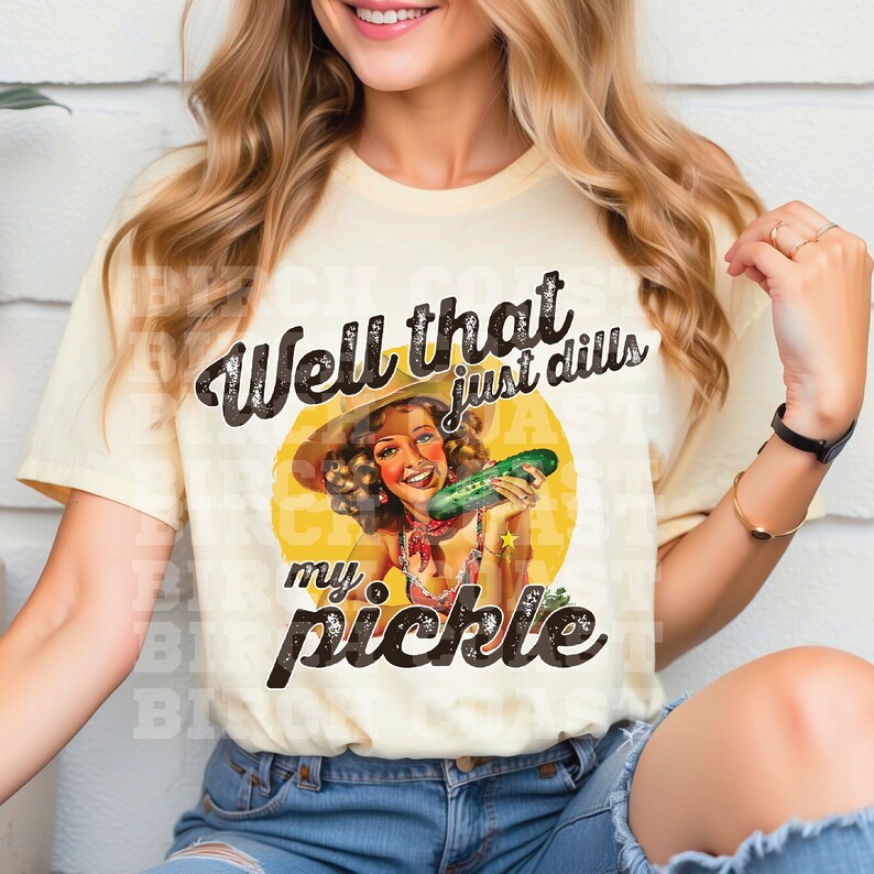Pu&ograve; includere: Una maglietta gialla con una grafica in stile vintage di una donna che tiene un cetriolo. Il testo sulla maglietta recita "Well that just dills my pickle".