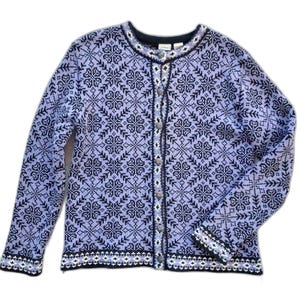 May include: A long-sleeve knit cardigan in light purple and dark navy blue. The garment features a repeating geometric snowflake pattern across the front, back, and sleeves, with a button-down front closure and a dark navy blue ribbed collar.