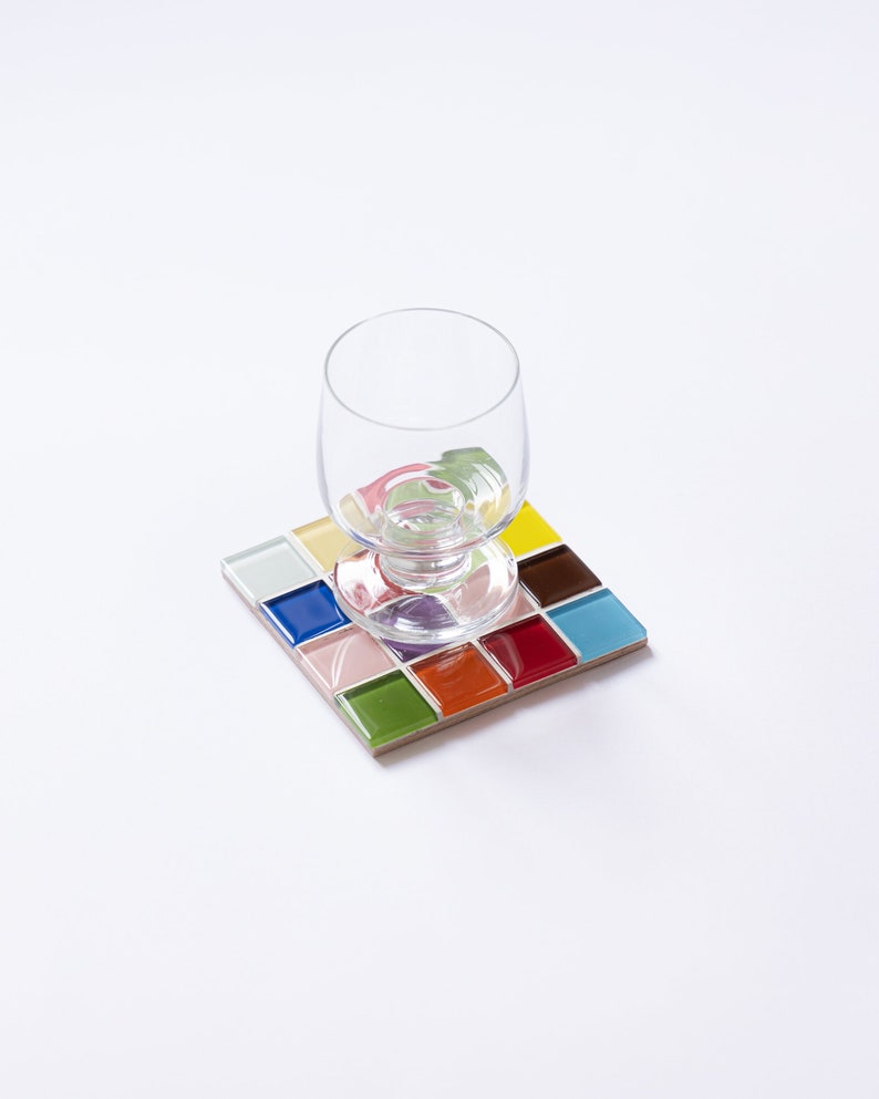 Square tile coaster made with a high-quality mix of glass and stone mosaic pieces. This handmade drink coaster adds style and texture to your tabletop and makes a charming gift for her during the holidays, birthdays, or as a unique thank-you gesture. Ideal for farmhouse kitchens, modern lofts, or eclectic decor lovers who appreciate craftsmanship and handmade beauty.